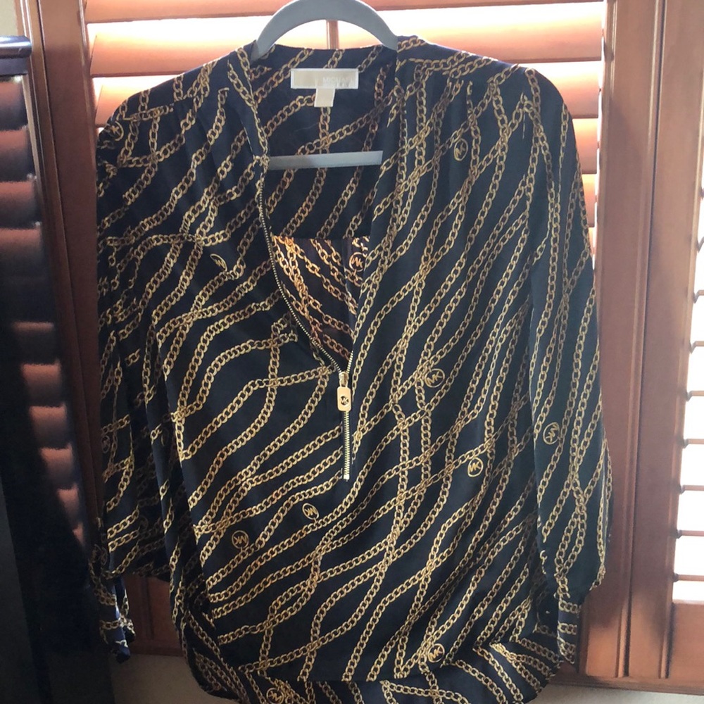 a black michael kors blouse and has chains in the print